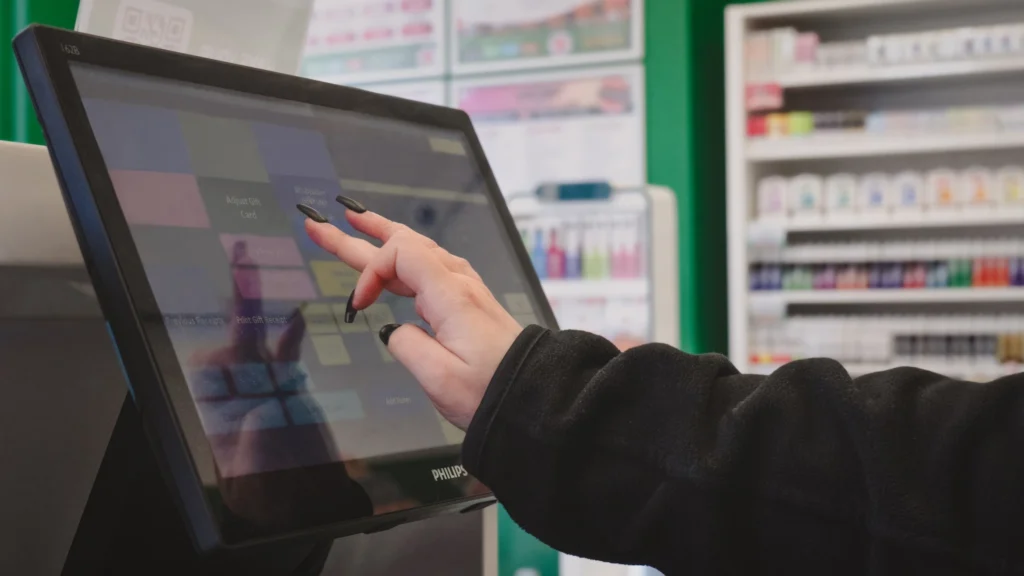A person using a touch screen till in a shop